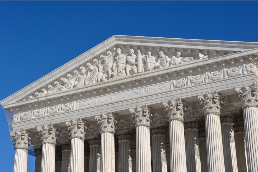 [ai] The facade of a neoclassical building featuring tall columns and a triangular pediment with sculptural reliefs. The inscription "EQUAL JUSTICE UNDER LAW" is visible above the entrance, against a clear blue sky.